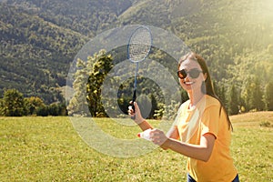 Woman playing badminton in mountains on sunny day. Space for text