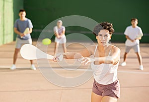 Woman playing Basque pelota on outdoor pelota court photo