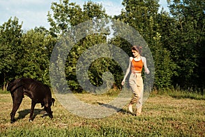 woman playing with a big black dog outdoors in the field fun friendship