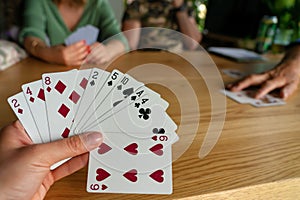 Woman playing with cards with friends close up