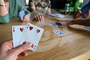 Woman playing with cards with friends close up