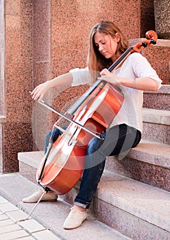 Woman playing cello on the stairway