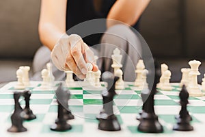 Woman playing chess board game at home.