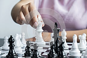 Woman playing chess and thinking strategy plan about crash overthrow the opposite team and development analyze for successful