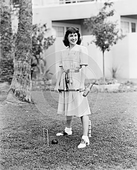 Woman playing croquet in the yard