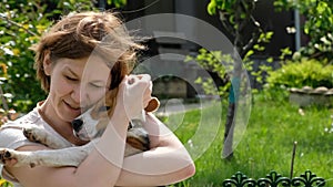 Woman playing with cute dog beagle, summer outdoors