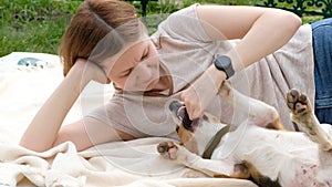 Woman playing with cute dog beagle, summer outdoors