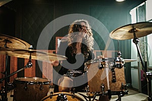 Woman playing drums during music band rehearsal