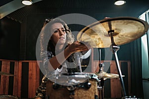 Woman playing drums during music band rehearsal