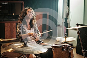 Woman playing drums during music band rehearsal