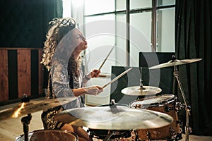 Woman playing drums during music band rehearsal