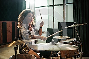 Woman playing drums during music band rehearsal photo