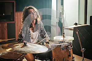 Woman playing drums during music band rehearsal