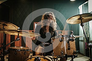 Woman playing drums during music band rehearsal photo