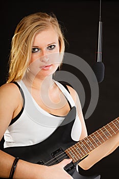 Woman playing on electric guitar and singing