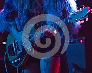 Woman playing electric guitar on stage