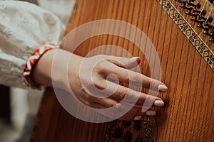 Woman playing on ethnic traditional ukrainian instrument bandura or pandora