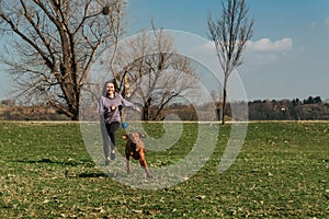 Woman Playing Fetch with Vizsla Dog in Park