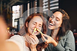 Woman playing with food and laughing in restaurant