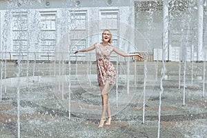 Woman is playing in a fountain.