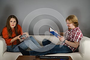 Woman playing games man reading book