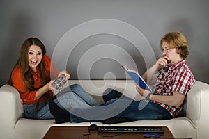 Woman playing games man reading book