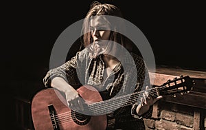 Woman playing guitar, holding an acoustic guitar in his hands. Music concept. Girl guitarist plays. Girl play the guitar