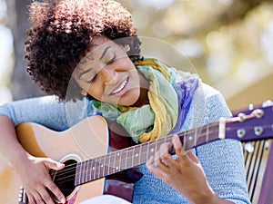 Woman playing guitar in park