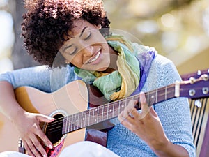 Woman playing guitar in park