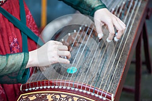 Woman playing Guzheng traditional chinese music instrument