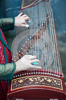 Woman playing Guzheng traditional chinese music instrument