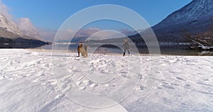 Woman playing with her Airedale Terrier dog in snow