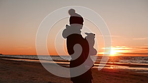 Woman playing with her dog at sunset near baltic sea