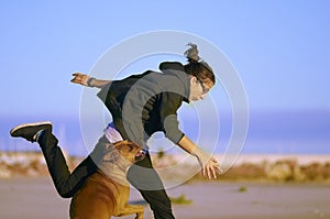 Woman playing with her dogs on a beach