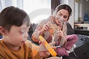 Woman playing with her son with genetic disorder and pretends to take a picture of him