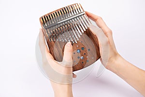 Woman playing for kalimba close up. Kalimba or Mbira is an African musical instrument in hands on white background. Music concept