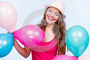 Woman playing with many colorful balloons