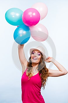 Woman playing with many colorful balloons