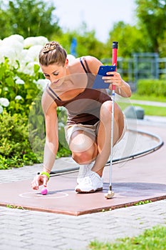 Woman playing miniature golf