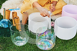 Woman playing music on crystal singing bowls