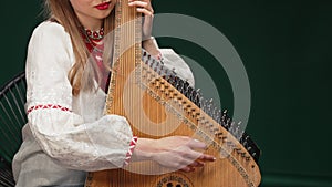 Woman playing on old traditional ukrainian stringed instrument bandura or kobza