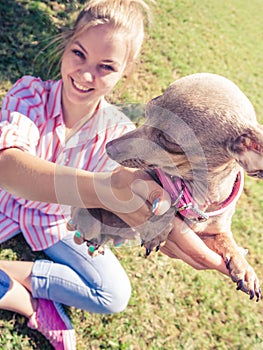 Woman playing pinscher ratter dog outside