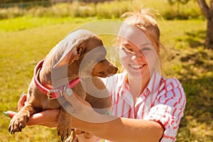 Woman playing pinscher ratter dog outside