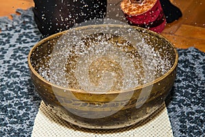 Woman playing a singing bowls also known as Tibetan Singing Bowls, Himalayan bowls.