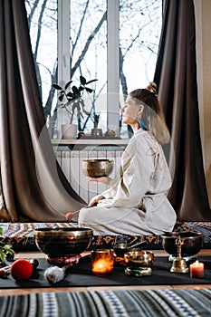 Woman playing on singing bowls, music sound treatment. Mental health