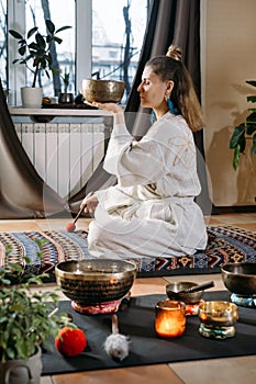 Woman playing on singing bowls, music sound treatment. Mental health