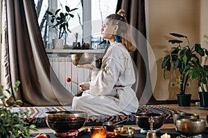 Woman playing on singing bowls, music sound treatment. Mental health