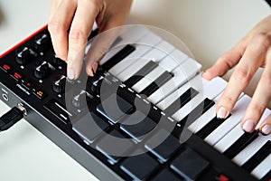 Woman playing a small modern music synthesizer