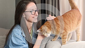 woman playing and stroking a cat