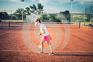 Woman playing tennis on clay court, with sporty outfit and healthy lifestyle